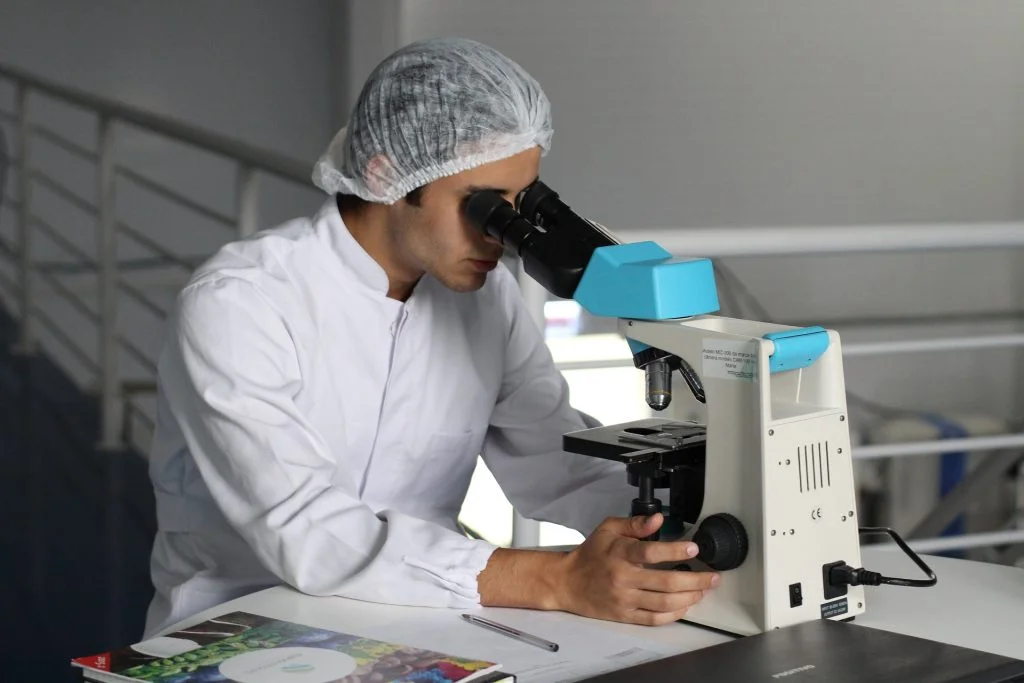 Researcher Looking Into Microscope